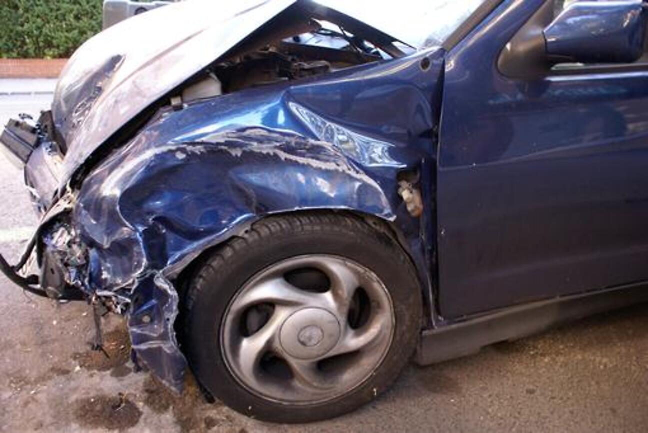 Collision damage to the front quarter panel of a car