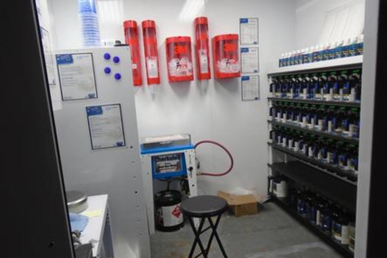 The shop's paint mixing room with tinted paint stock and mixing equipment